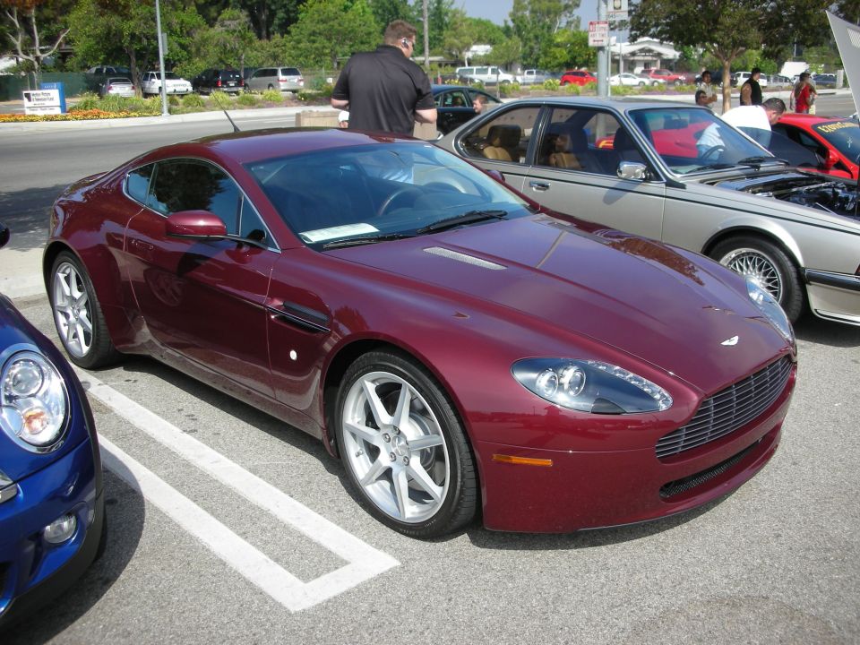 Maroon Aston Martin Vantage parked next to a blue Mini Cooper and a silver BMW