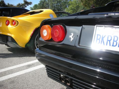1998 Ford Crown Victoria - Two sports cars, a black Ferrari and a yellow Lotus, are parked together.