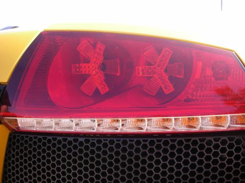 1998 Ford Crown Victoria - The distinctive X-shaped LED pattern in the taillight is visible on this yellow vehicle.