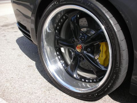 1998 Ford Crown Victoria - Close-up of a custom wheel on a black car, yellow Porsche brake calipers and a polished lip.