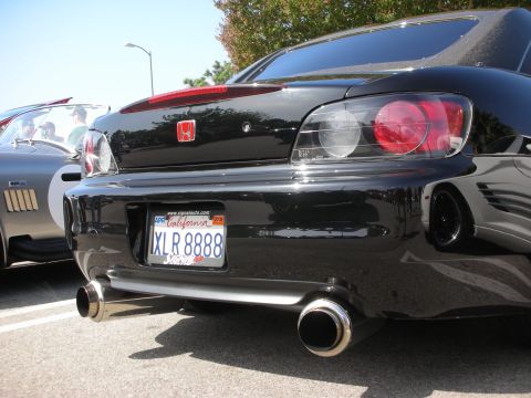 1998 Ford Crown Victoria - Rear view of a black Honda S2000, its distinctive taillights and dual exhaust system, parked next to another vehicle.