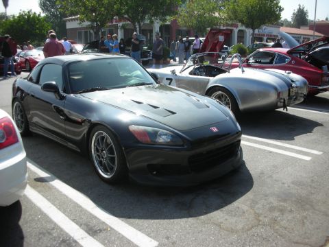 1998 Ford Crown Victoria - Several sports cars gathered at a meet, including a black Honda S2000 and a silver AC Cobra.