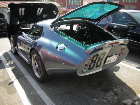 1998 Ford Crown Victoria - A custom Shelby Cobra with its hood and trunk open, parked next to another vehicle.