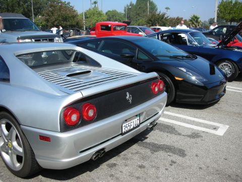 1998 Ford Crown Victoria - A line of cars at a meet, including a silver Ferrari F355, a black Lamborghini Gallardo, and a blue Ford Mustang.