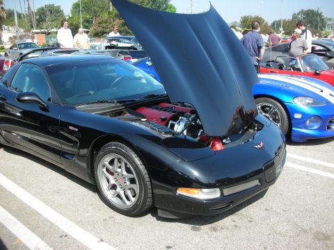 1998 Ford Crown Victoria - A black Chevrolet Corvette C5 is parked with its hood open, revealing the engine, next to a blue Dodge Viper.
