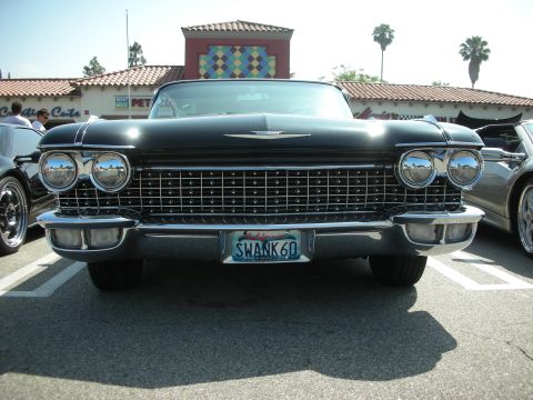 1998 Ford Crown Victoria - A black 1960 Cadillac convertible is parked at a meet, with a California license plate reading 'SWANK 60'.