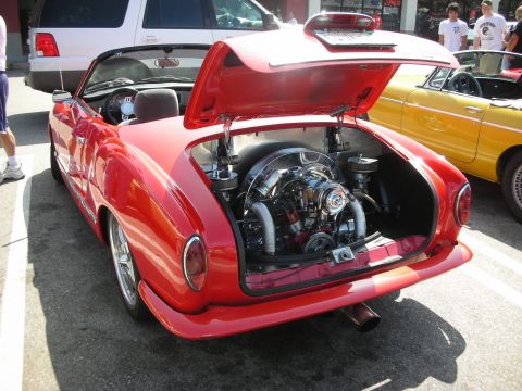 1998 Ford Crown Victoria - A red convertible shows off its polished flat-four engine, parked next to a yellow convertible and a white SUV.