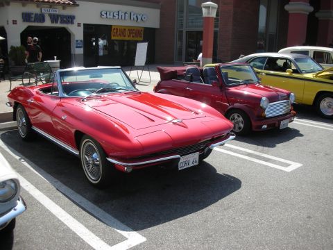 1998 Ford Crown Victoria - Three classic cars parked in a lot outside a restaurant.