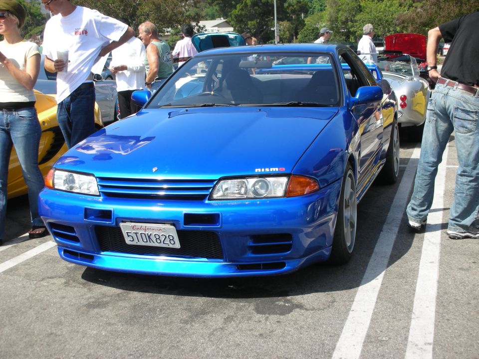 Blue Nissan Skyline GT-R R32 with NISMO badge, California license plate 5TOK828, parked in a lot