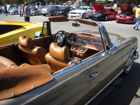 1998 Ford Crown Victoria - A classic convertible with a tan interior is parked at a car meet, with several other vehicles visible in the background.
