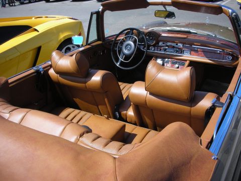 1998 Ford Crown Victoria - Interior view of a classic convertible, with a yellow sports car in the background.