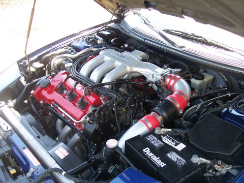 1995 Ford Probe - Engine bay shot from the passenger side showing a transverse Mazda V6 with a red-painted valve cover and silver upper intake plenum. A poli…