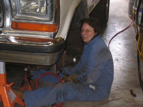1979 Ford Bronco - Mechanic works on the front wheel hub of a 1979 Ford Bronco.