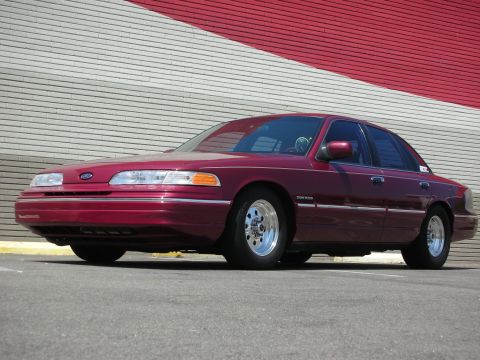 1992 Ford Crown Victoria - 1992 Ford Crown Victoria with custom wheels sits parked outdoors.