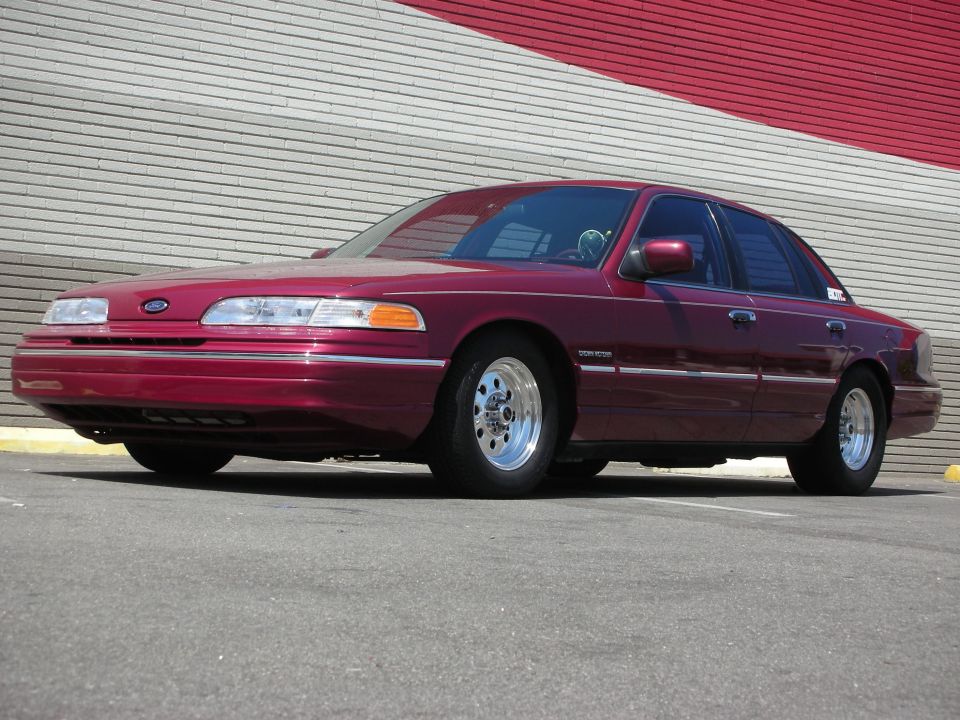 Maroon 1992 Ford Crown Victoria with chrome wheels parked outside