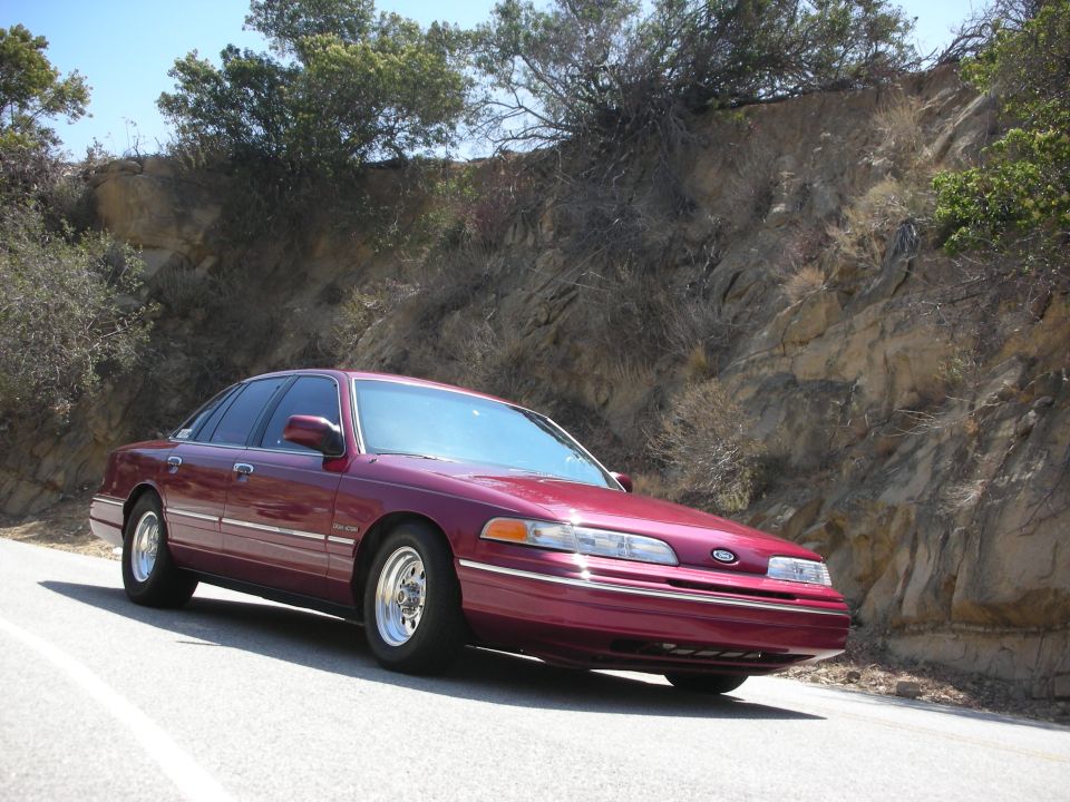 Maroon 1992 Ford Crown Victoria parked on a winding road