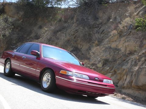 1992 Ford Crown Victoria - 1992 Ford Crown Victoria on a road with a rocky hillside in the background.