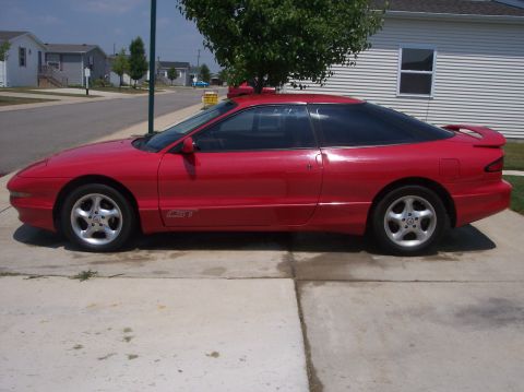 1996 Ford Probe - Side profile of a red 1996 Ford Probe GT with tinted windows and a rear spoiler.