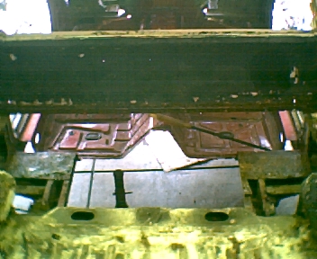 1966 Ford Ranchero - Interior view of a heavily rusted car floor pan, showing structural damage.