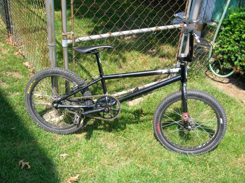 1997 Ford Probe - A black BMX bicycle is shown outdoors, leaning against a fence.