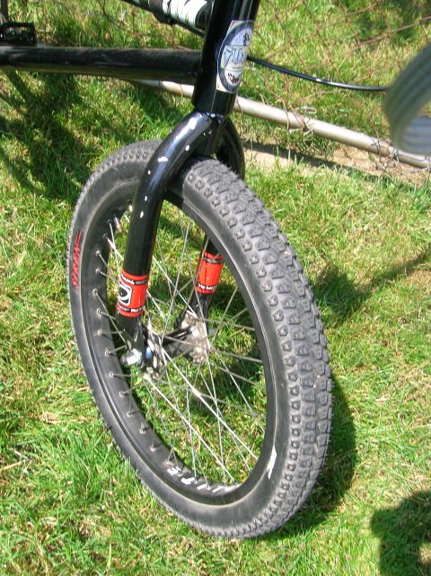 1997 Ford Probe - Close-up of a bicycle's front wheel and suspension fork, set against a grassy background.