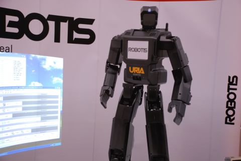 1996 Ford Bronco - A black humanoid robot stands in front of a display with "ROBOTIS" branding and a projected computer screen.