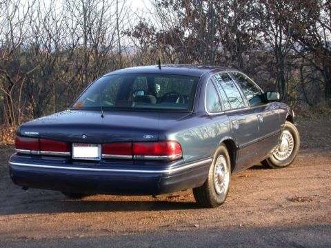 1995 Ford Crown Victoria - A 1995 Ford Crown Victoria sedan is seen from the rear quarter angle, parked outdoors.