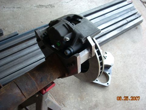 2000 Chevrolet Tahoe - Close-up of a vehicle's rear axle assembly, a brake caliper and rotor, supported by jack stands.