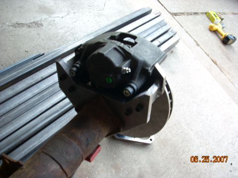 2000 Chevrolet Tahoe - A close-up view of a brake caliper and rotor assembly attached to a differential axle.