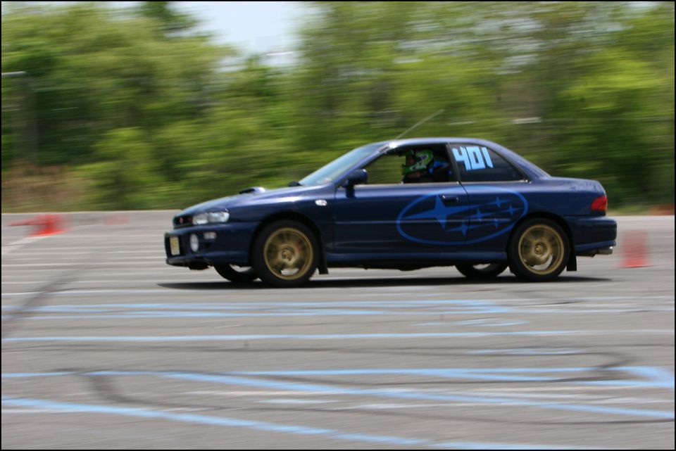 Blue Subaru Impreza WRX STI with gold wheels and number 401 on door, side view