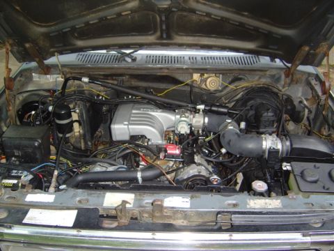 1986 Ford Bronco - Engine bay view showing a Ford Mustang intake manifold and complex wiring harness.