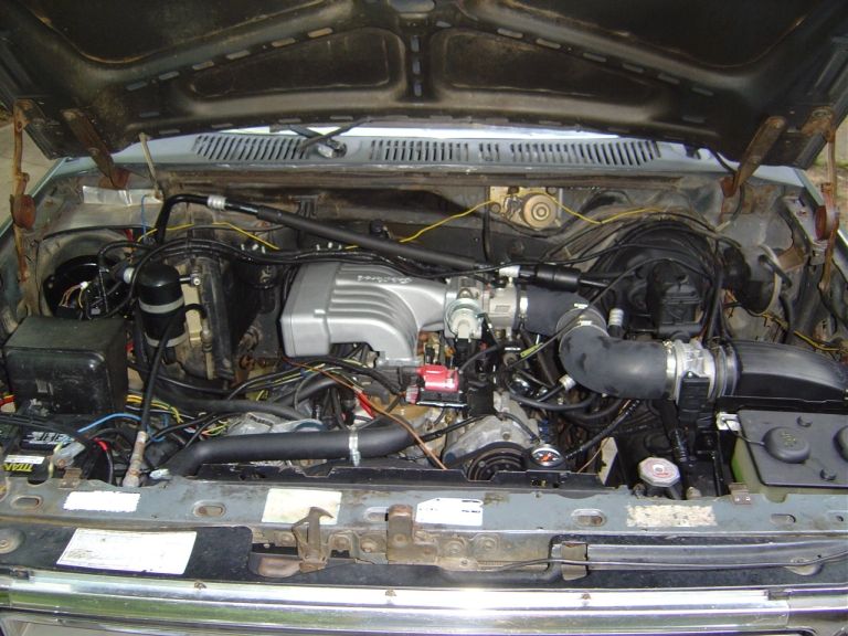 Engine bay with gray intake manifold, hoses and wiring