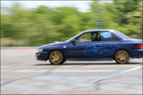 2001 Mercury Grand Marquis - Blue Subaru Impreza WRX STI coupe with gold wheels and large side decal, number 400 on door, on a race track.