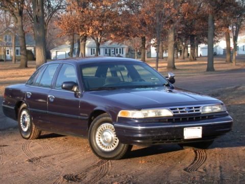 1995 Ford Crown Victoria - Dark purple 1995 Ford Crown Victoria sedan with chrome wheels parked outdoors.