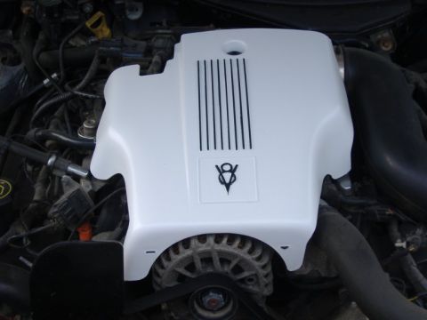 2003 Ford Crown Victoria - Close-up view of an engine bay, focusing on a white engine cover with a V8 emblem.