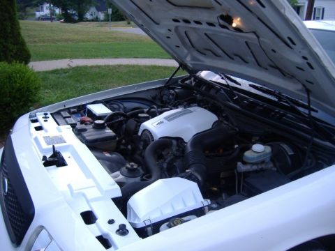 2003 Ford Crown Victoria - The engine bay of a white 2003 Ford Crown Victoria is shown with the hood open.