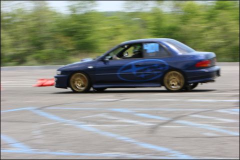 2001 Mercury Grand Marquis - Blue Subaru Impreza WRX STI coupe with gold wheels navigates a race track course.