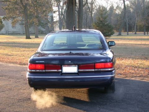 1995 Ford Crown Victoria - The rear of a 1995 Ford Crown Victoria is shown with exhaust smoke billowing from the tailpipe.