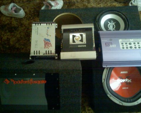 1901 Honda Odyssey - Several car audio amplifiers and subwoofers are laid out on a carpeted surface.