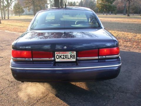 1995 Ford Crown Victoria - Rear view of a dark blue 1995 Ford Crown Victoria parked outdoors on a paved surface.
