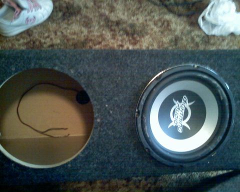 1901 Honda Odyssey - A close-up view of a subwoofer speaker within a dual-chamber enclosure, with visible wiring.
