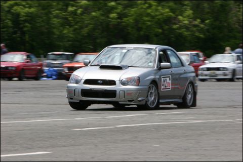 2001 Mercury Grand Marquis - Silver Subaru Impreza WRX STI sedan on a race track with other cars visible.