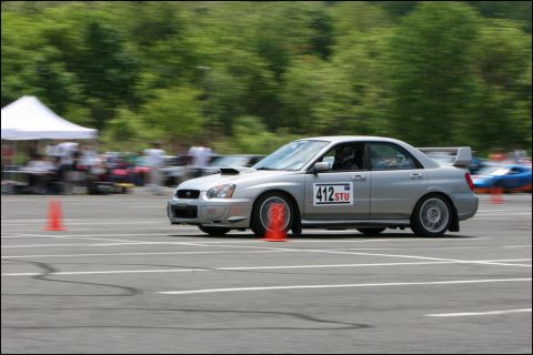 2001 Mercury Grand Marquis - Silver Subaru WRX STI sedan navigates an autocross course, displaying racing number '412 STU'.