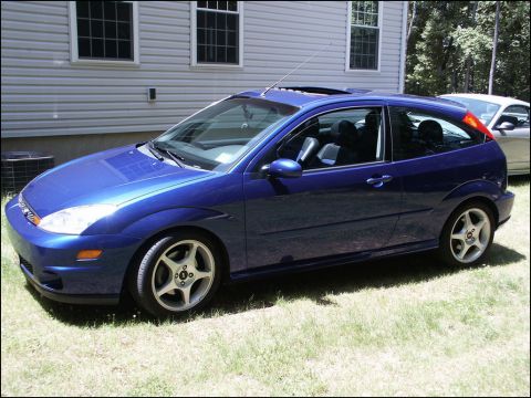 2001 Mercury Grand Marquis - Blue Ford Focus hatchback with a sunroof parked outside a house.