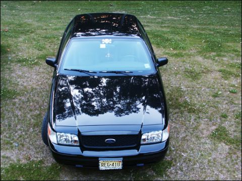 2001 Mercury Grand Marquis - A black 2001 Mercury Grand Marquis is seen from a high angle, parked on grass.