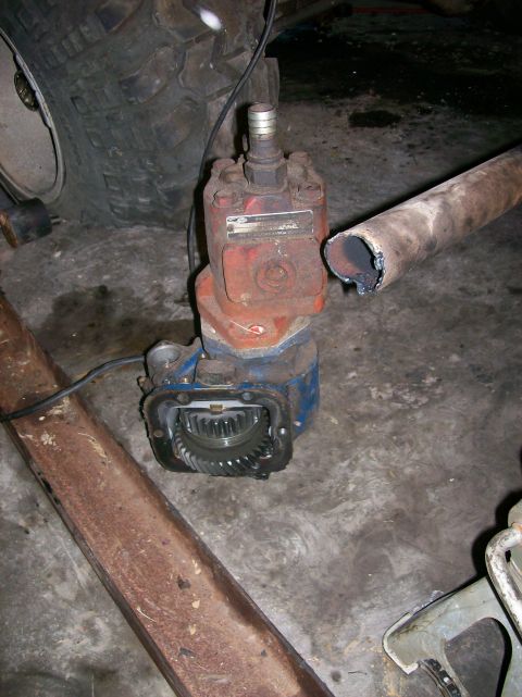 1982 Ford Bronco - Close-up of a vehicle differential with exposed gears, next to a large tire and exhaust pipe.