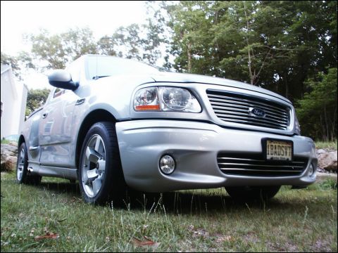 2001 Mercury Grand Marquis - Silver 2001 Ford F-150 SVT Lightning pickup truck with custom license plate 'IBADSVT'.