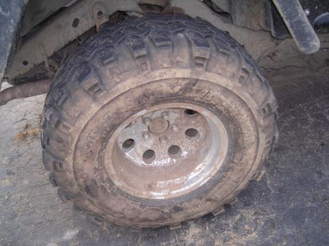 2003 Jeep TJ - Close-up of a dirty tire and wheel, suggesting off-road use.