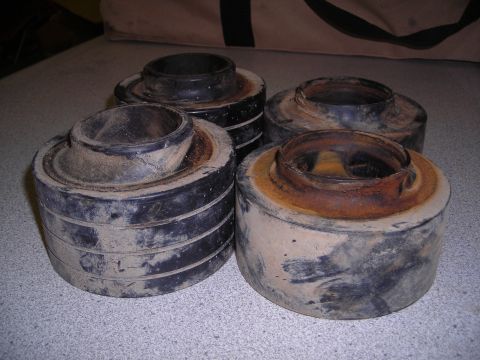 2003 Jeep TJ - Four used suspension lift spacers are shown, covered in dirt and rust.