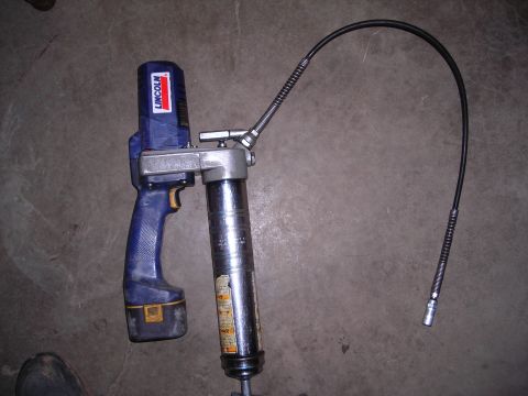 2003 Jeep TJ - Cordless Lincoln grease gun with a flexible hose attachment sits on a concrete surface.